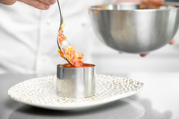 Kucharz mieszający sos w garnku